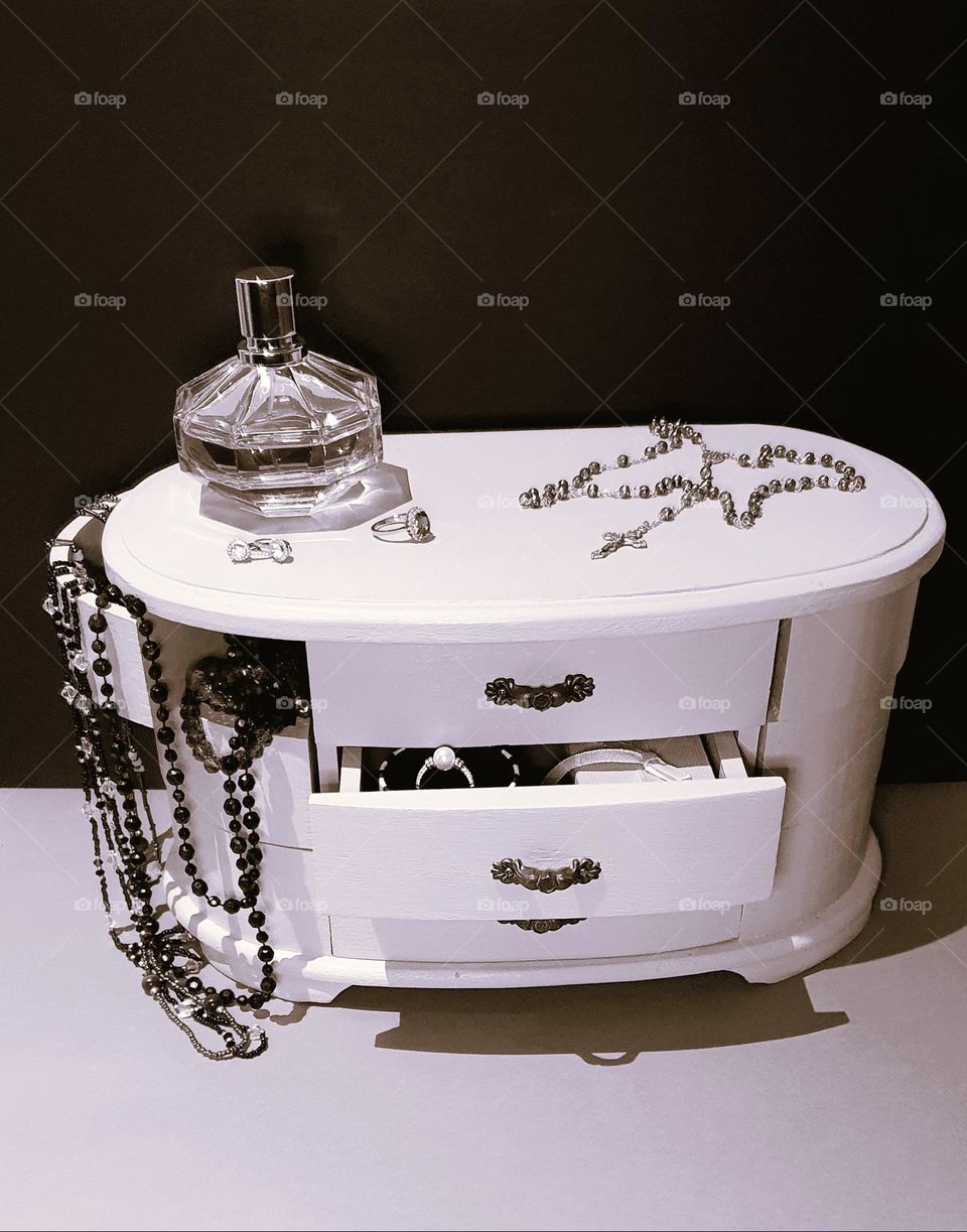 Sepia shot of a vintage composition made of a vintage jewellery box, perfum bottle, rosary and jewellery in and out of the box