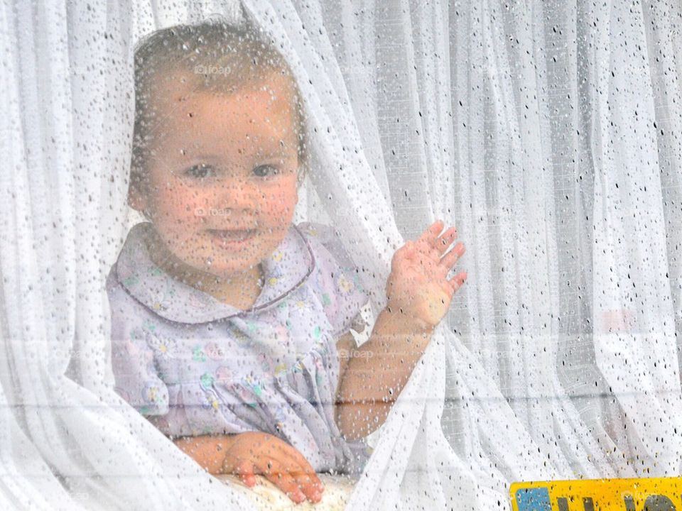 A baby in a caravan on a rainy day