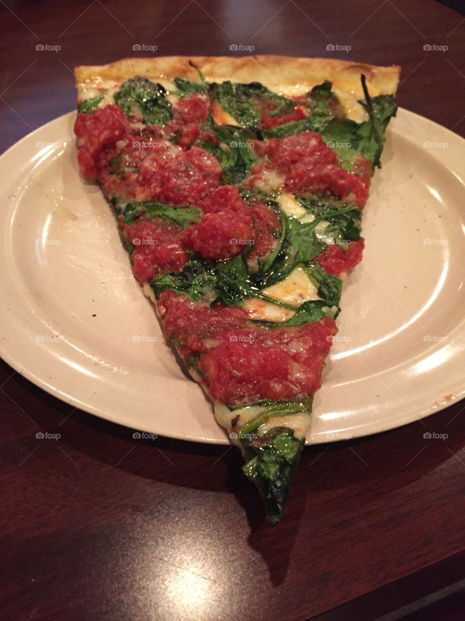 Spinach tomato pizza slice