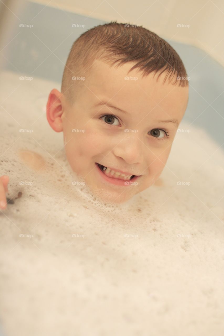 Child boy bathing in bath tub