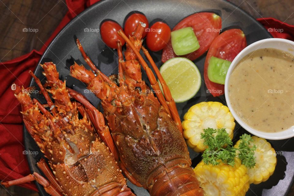 Lobster creamy garlic Lobster served with corn, tomatoes, lemon wedges, cherry and Asian-style creamy garlic sauce.