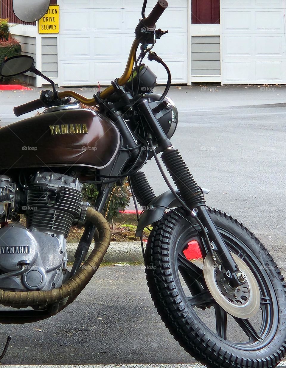 close up view of brown, gold and black motorcycle parked at an apartment complex on a week day in Oregon