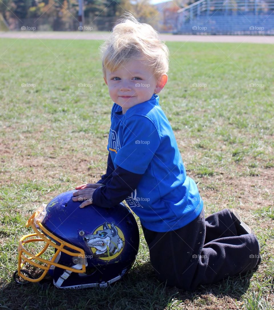 Boy with helmet on grass at playground