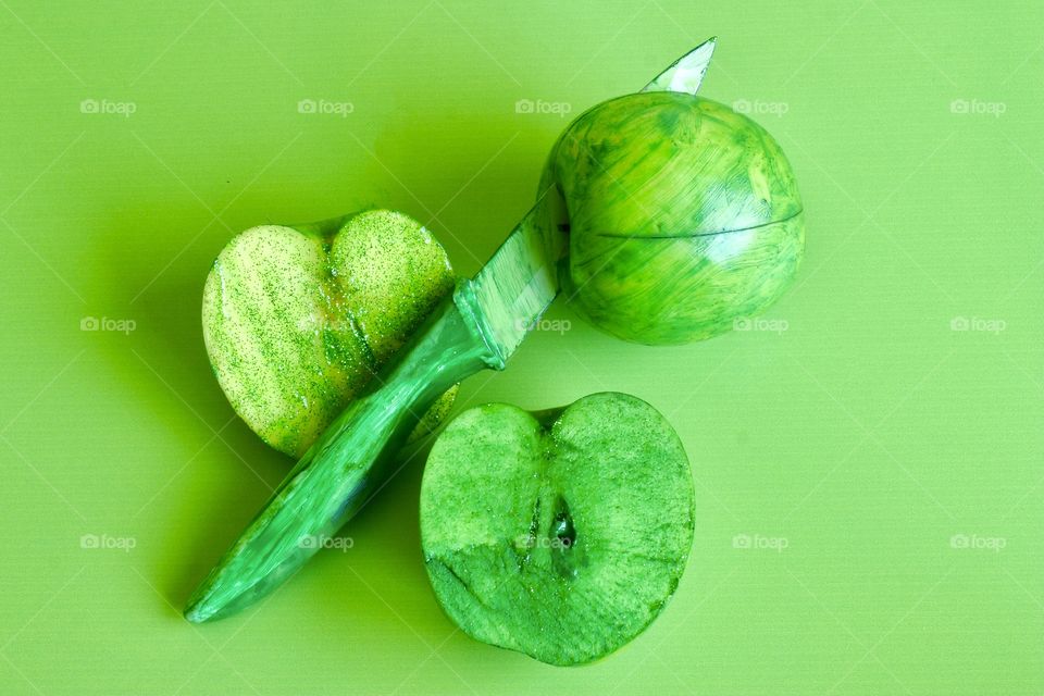 Monotone green apples, on green background, with green knife 