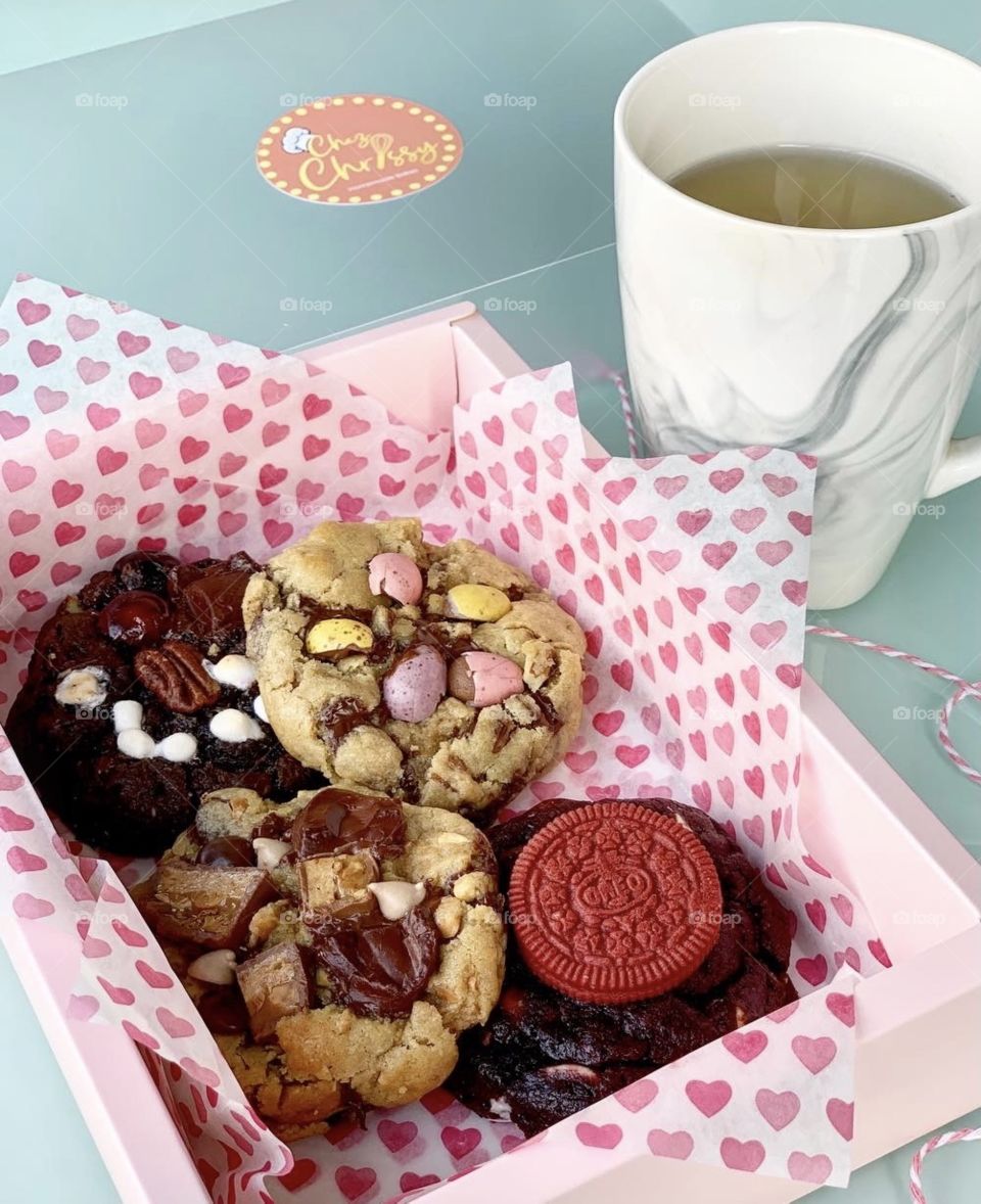 Freshly baked Gooey Easter cookies in chocolate in big chunk with hot tea for afternoon snack 