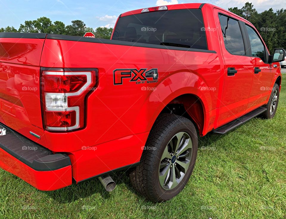 Beautiful red Ford FX4 OFF ROAD TRUCK resting in the grass