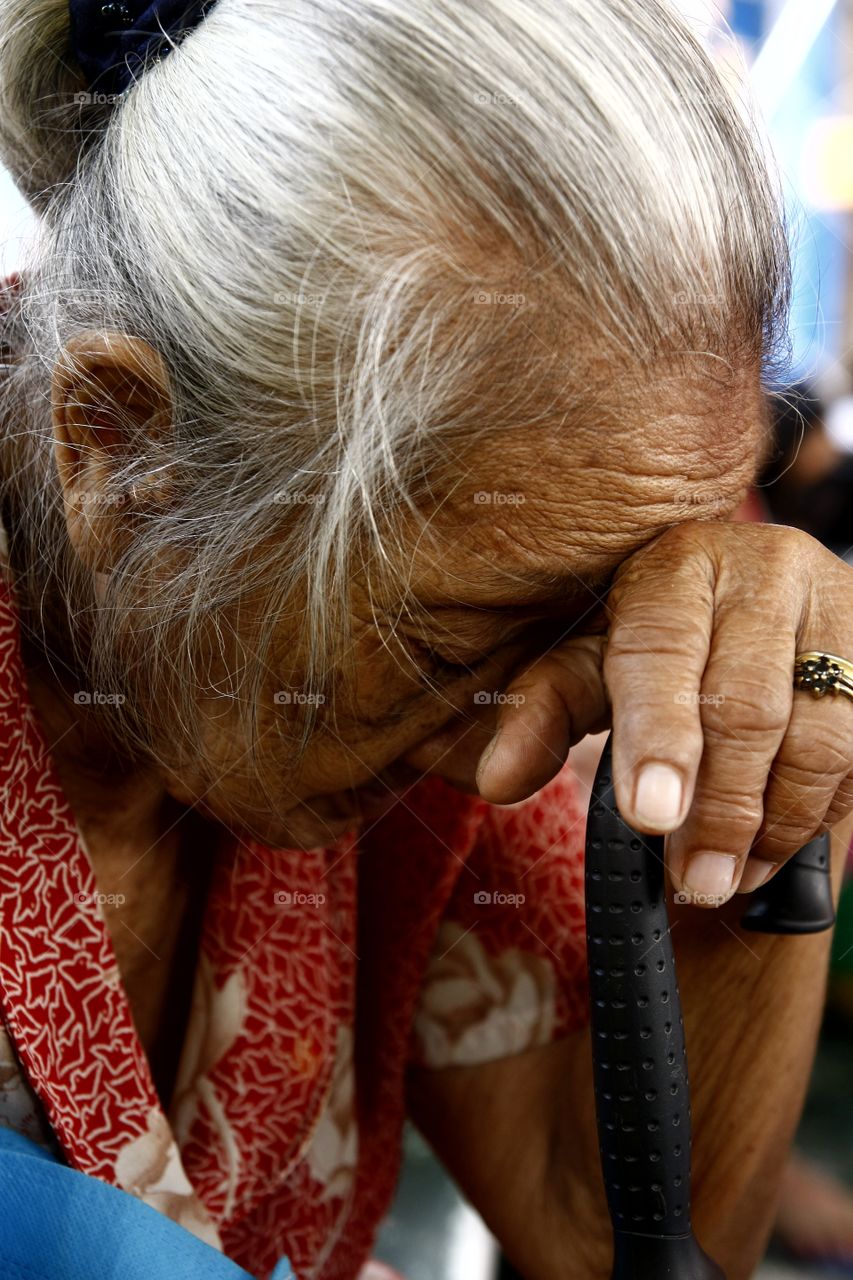 old woman resting on her cane. old woman resting on her cane