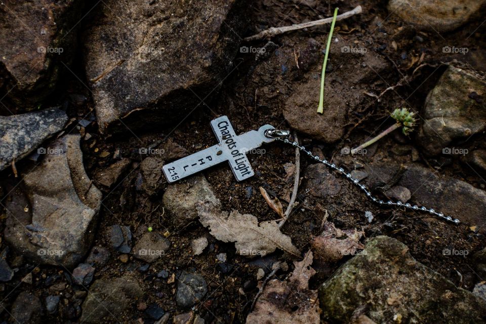 broken necklace sitting in the dirt
