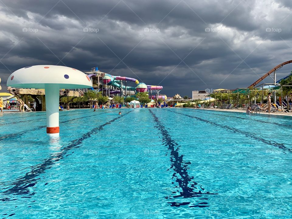 Swimming pool in the water park. Cloudy summer day.