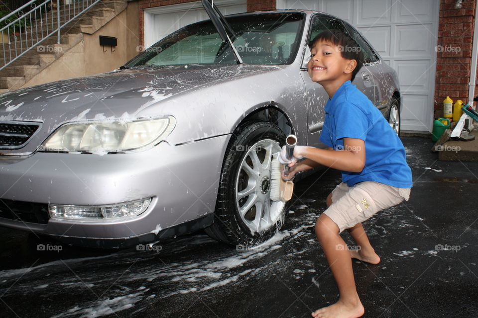 Funny boy washing a car