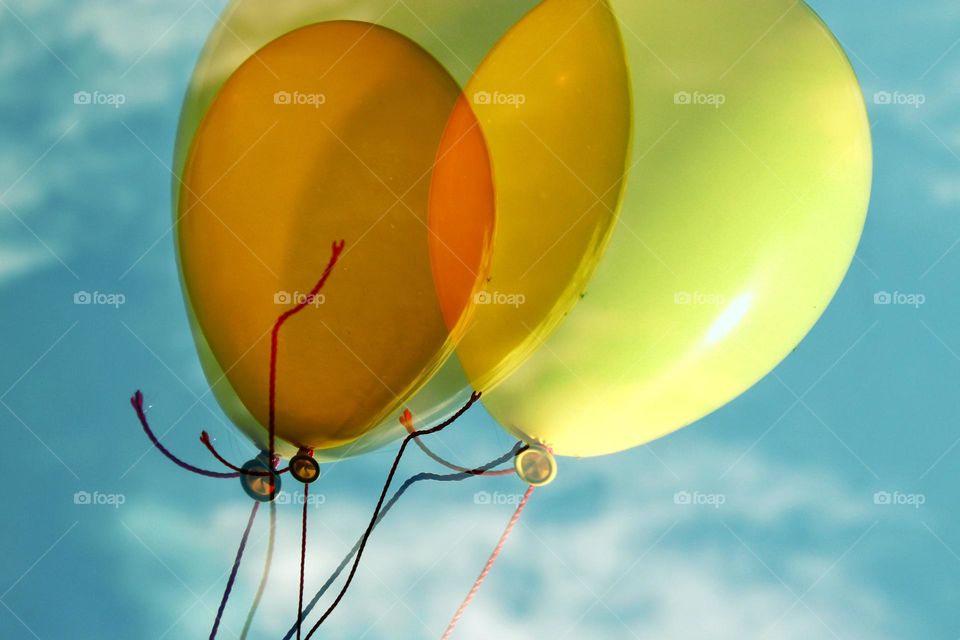 Double exposure of yellow balloons in the blue sky with clouds