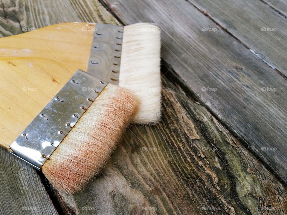 Two paint brushes on wooden table