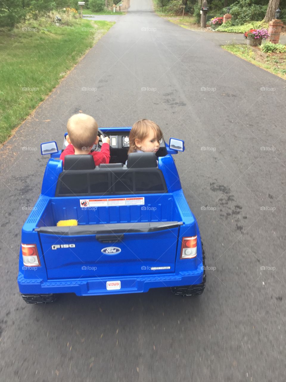 Brother and sister riding toy car