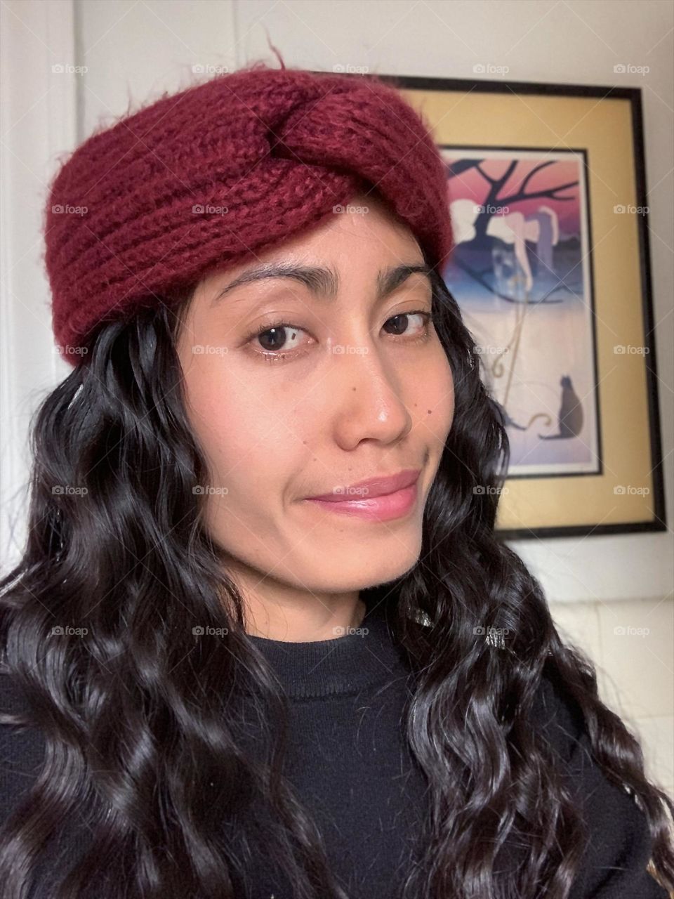 Selfie of a woman wearing a turban with wavy long hair.