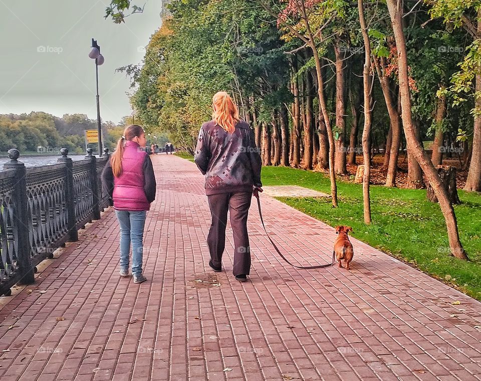 Mother and her daughter took a walk with their dog. 