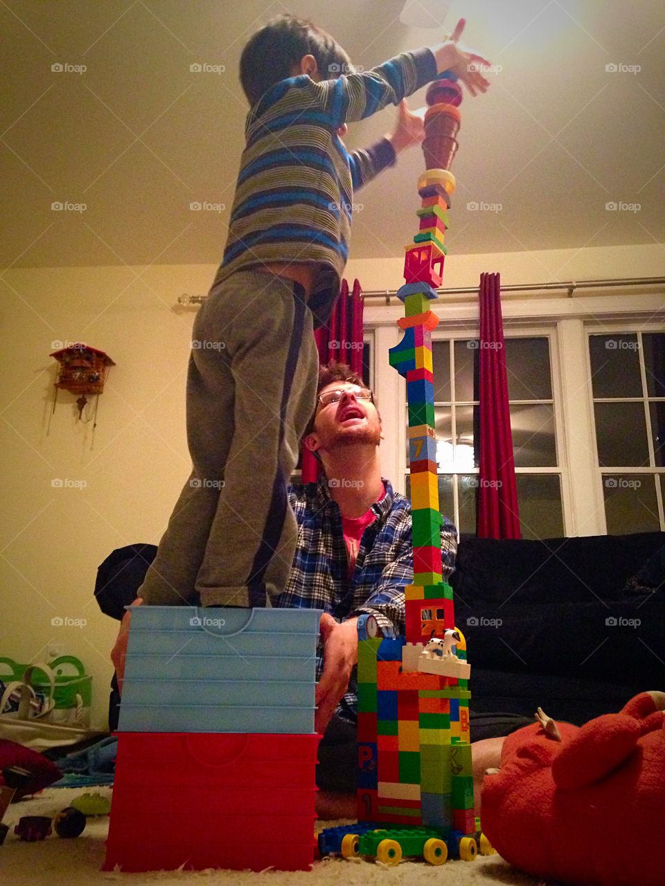 Kid and his dad play with building blocks