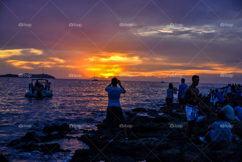 People at seashore during sunset