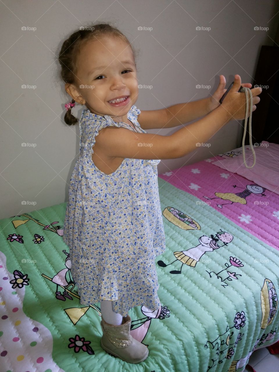 Toddler girl standing on bed