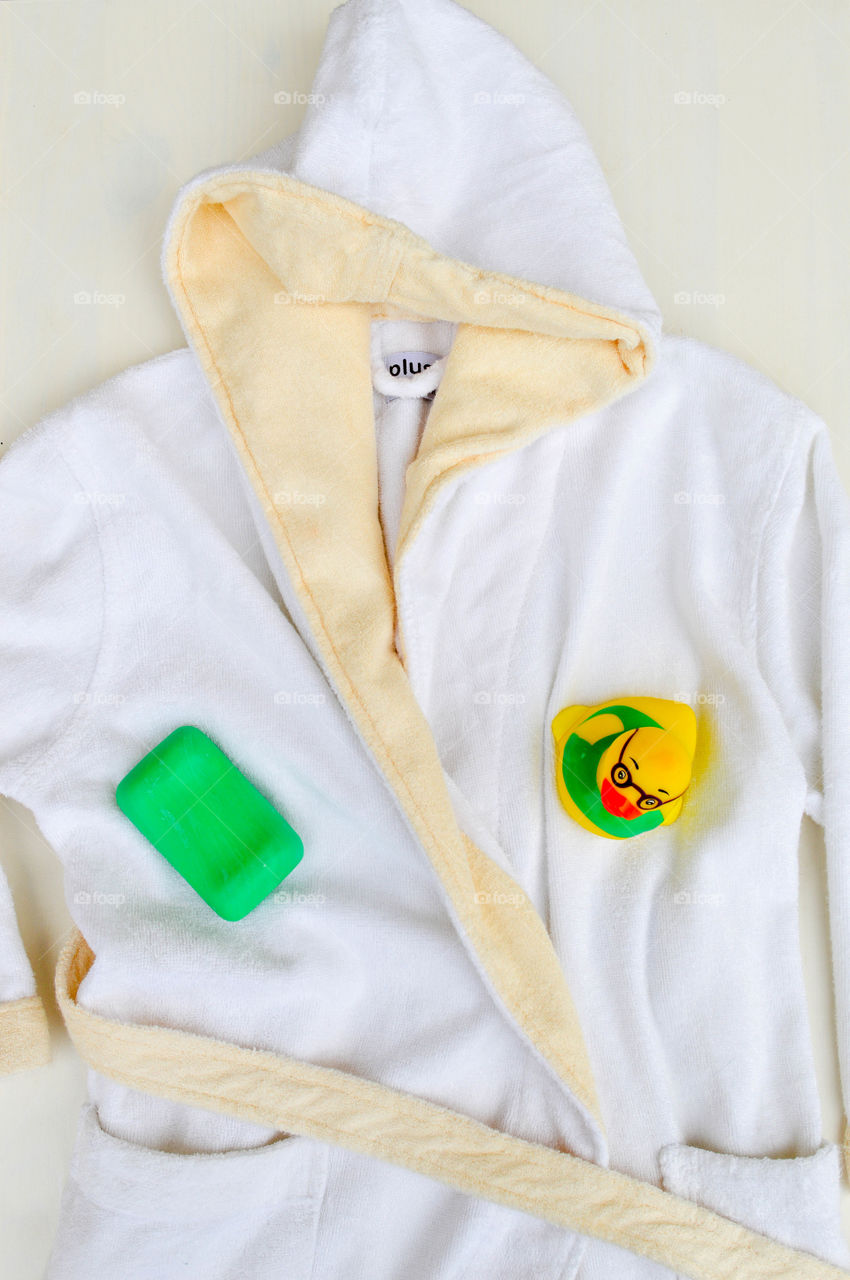 Child's bathrobe laid out with soap and a rubber duck
