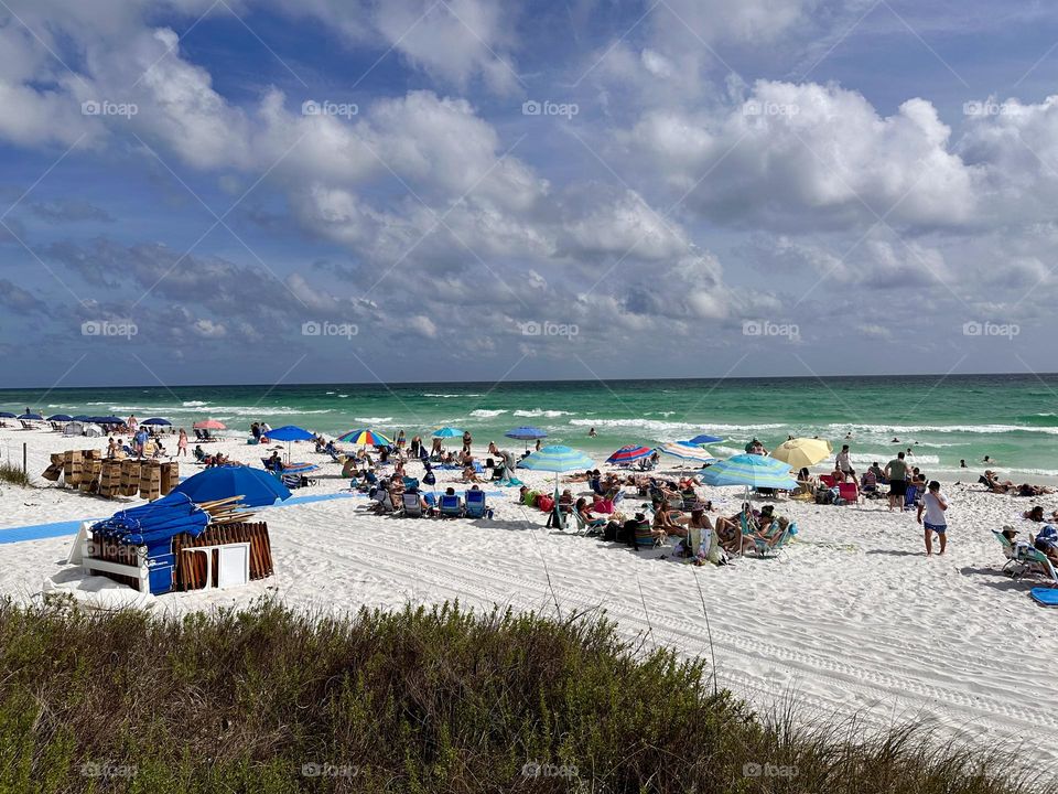 Swimmers and sunbathers relax at the beach with it’s distinctive green water and the famous white crystal sand 