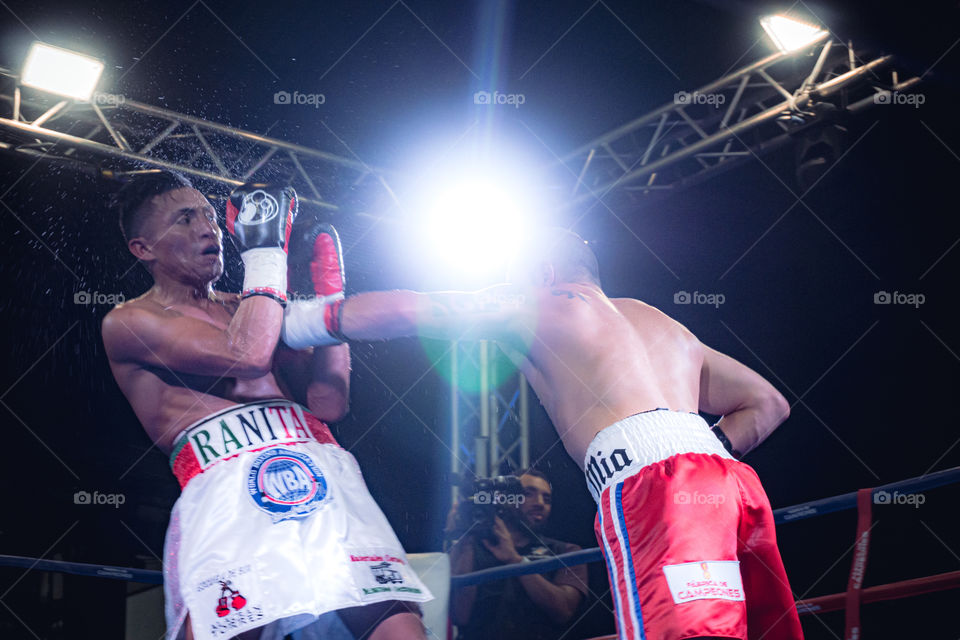 A couple of men on the move playing the sport of a boxing match