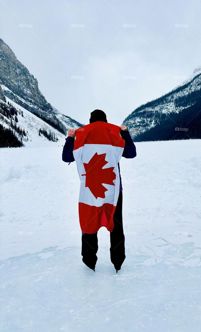 Me holding a Canadian flag skating on the iconic Lake Louise, Alberta, Canada.