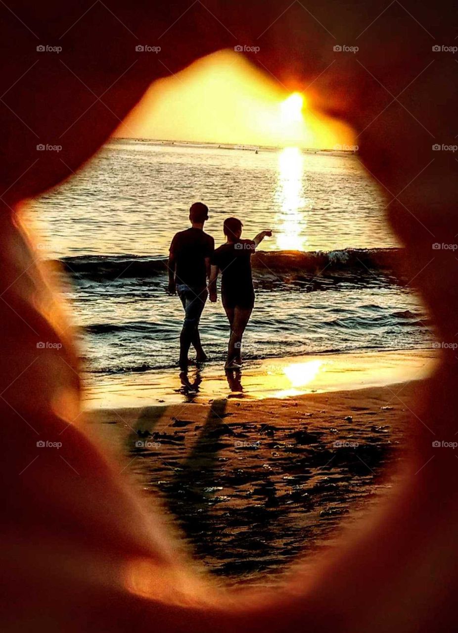 Silhouettes and shadows: a sweet couple at the beach sunset.