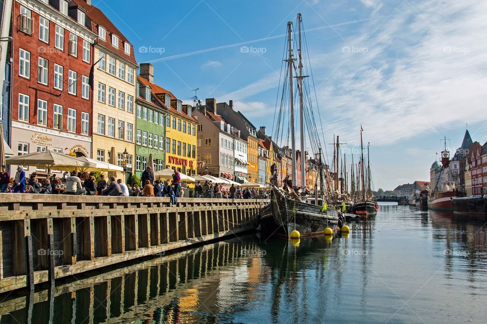 People enjoying Nyhavn in Copenhagen on a warm and sunny day in october