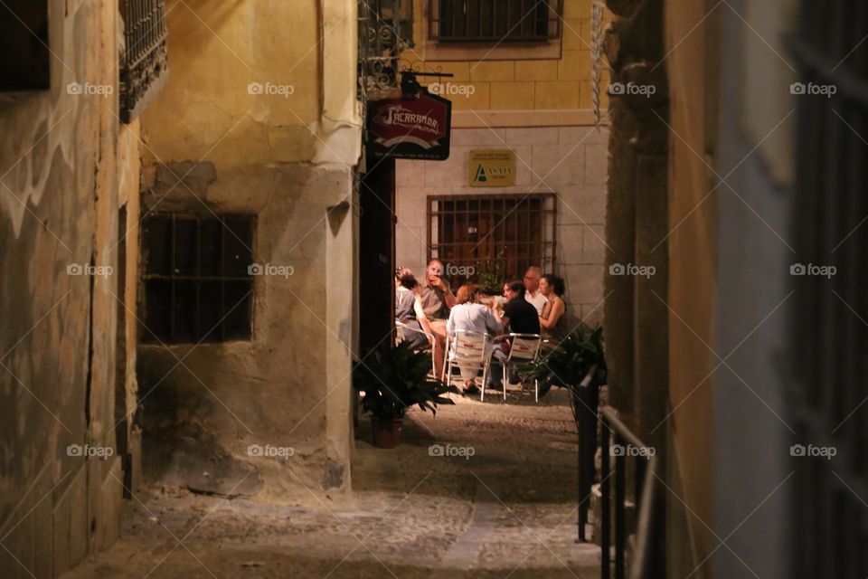 People sitting outdoors at a restaurant having dinner in a Spanish city