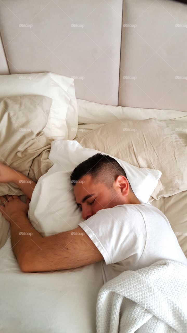 Young man sleeping in comfortable bed at home