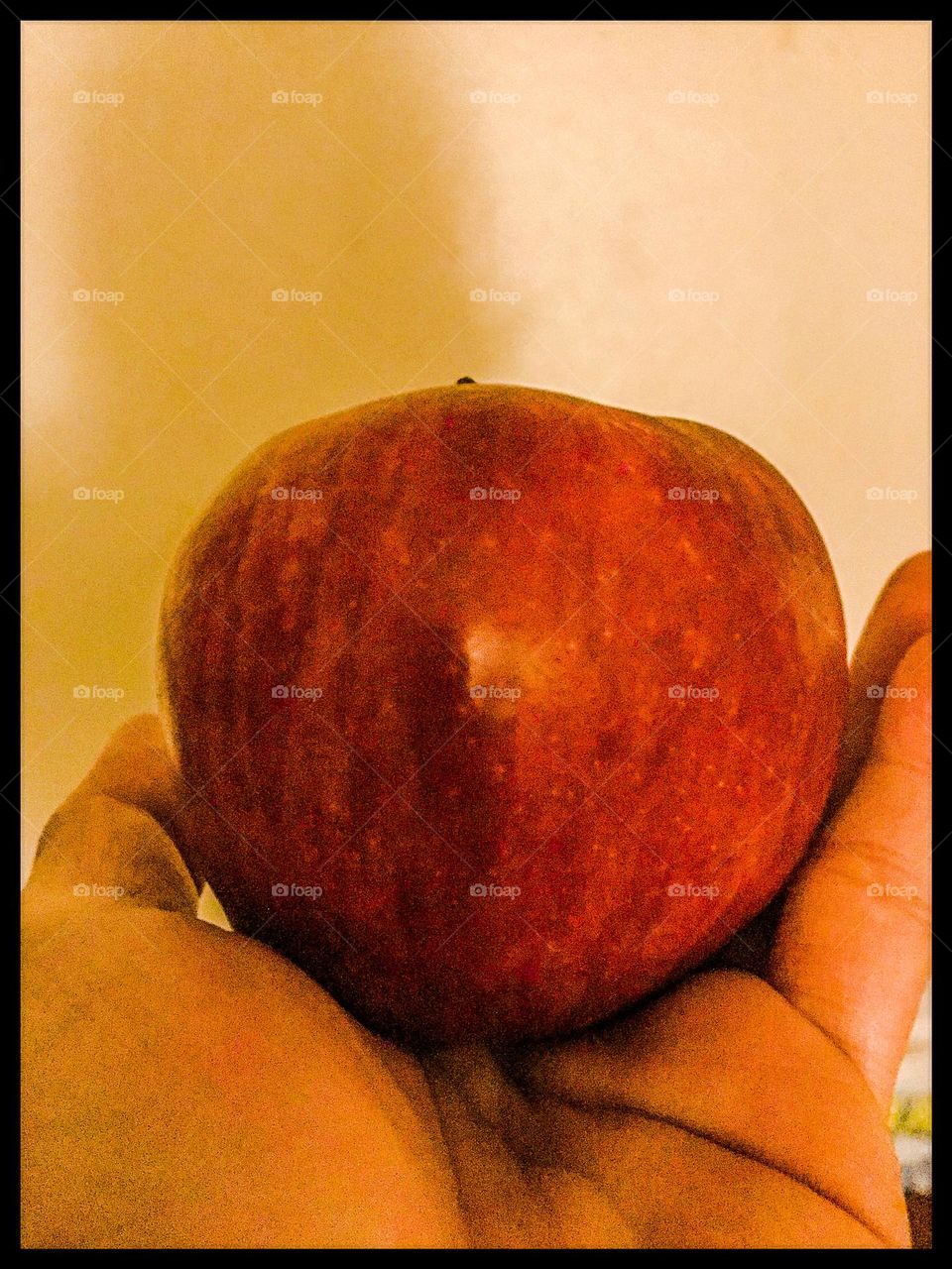 A red delicious apple in a hand.