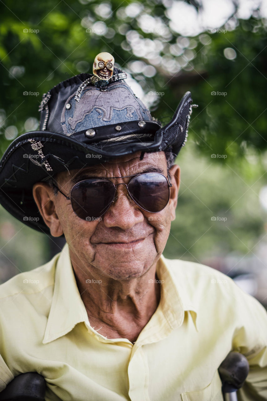 Senior adult in the park with hat and glasses