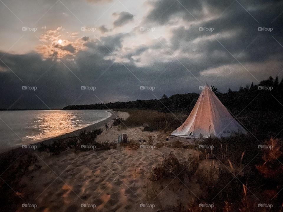 The view from one tent to another as the moon shines down on the lake.