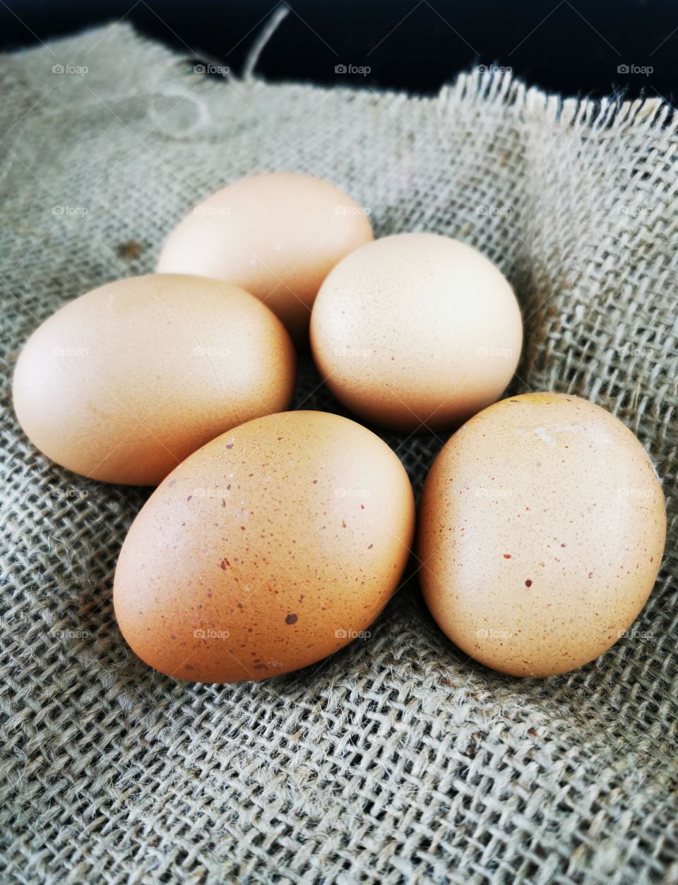 Brown eggs a piece of Jute. Fresh Brown Cage free eggs on burlap