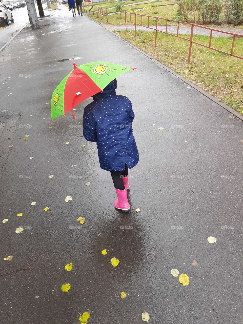 child in rainy weather walks with an umbrella