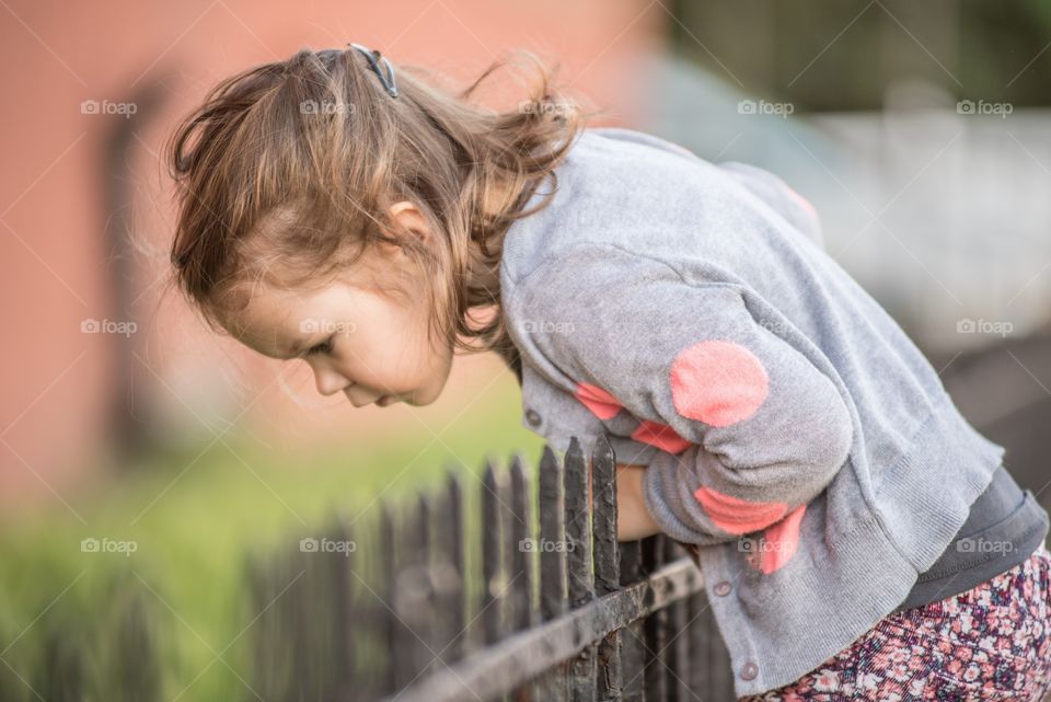 Small girl standing near railing