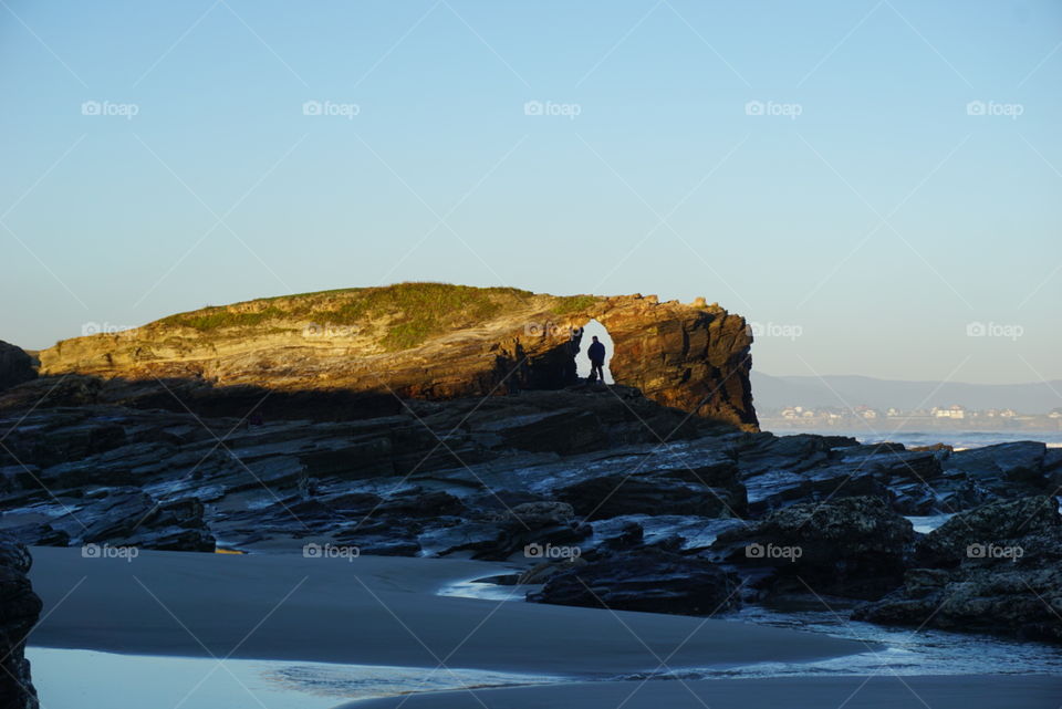 Rocks#beach#ocean#cave#human#sky