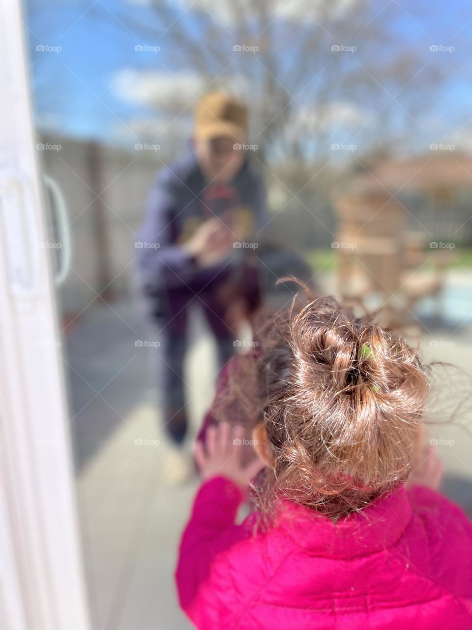 Reflections of mother and toddler in glass door, playing with reflections in the springtime, mother and toddler playing outside, enjoying the springtime weather 