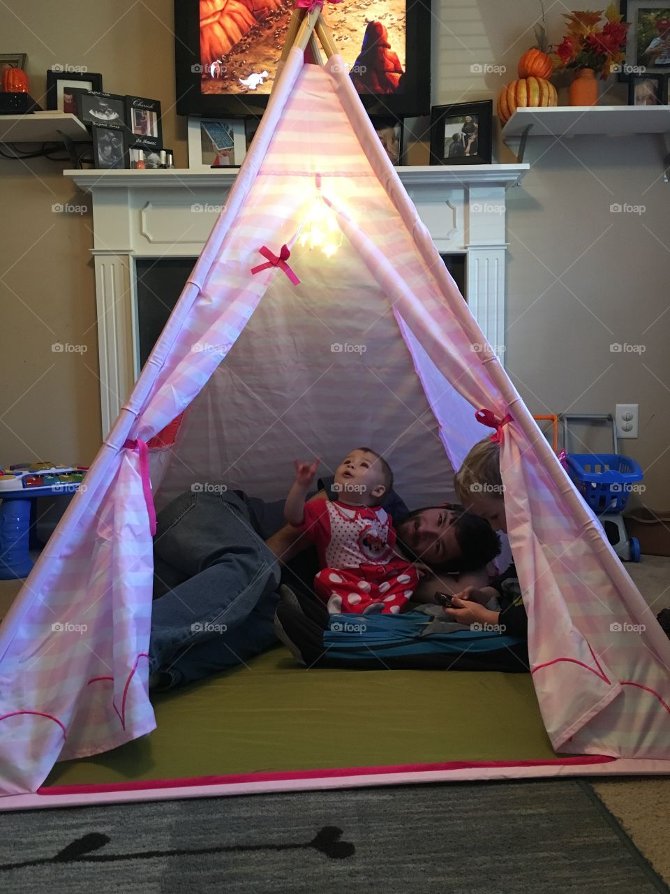 Man with children inside tent at home