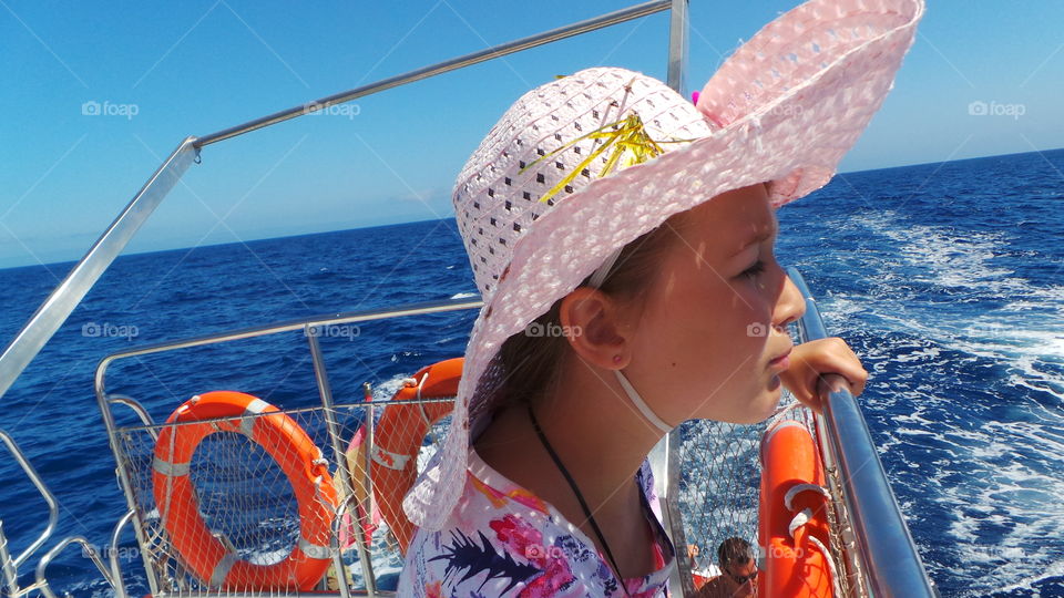 little girl on a boat looking out to sea