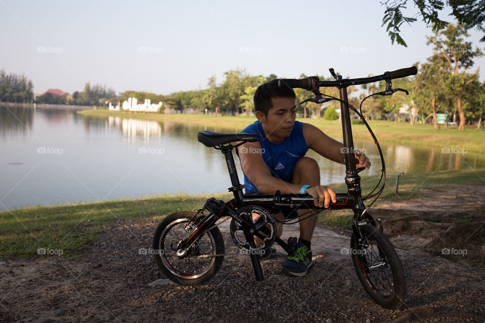 Man fixing bicycle in the park