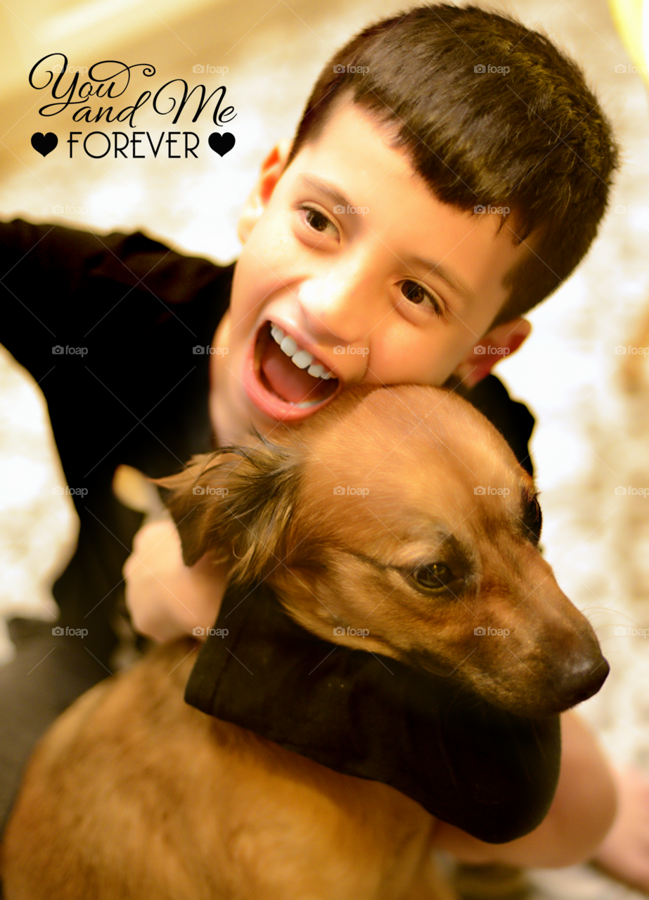 Boy embracing his dog with forever text