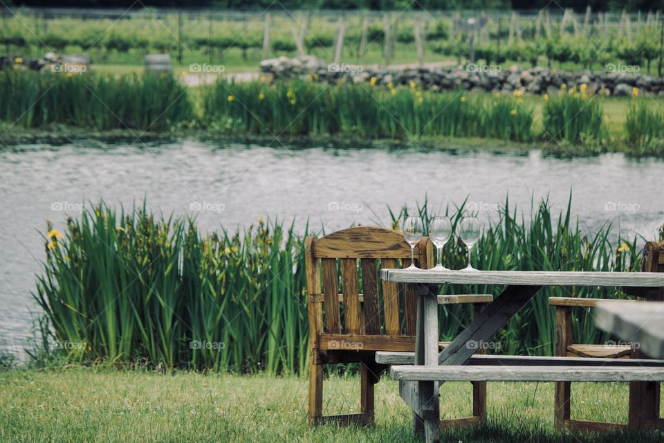 Three empty wine glasses by the lake