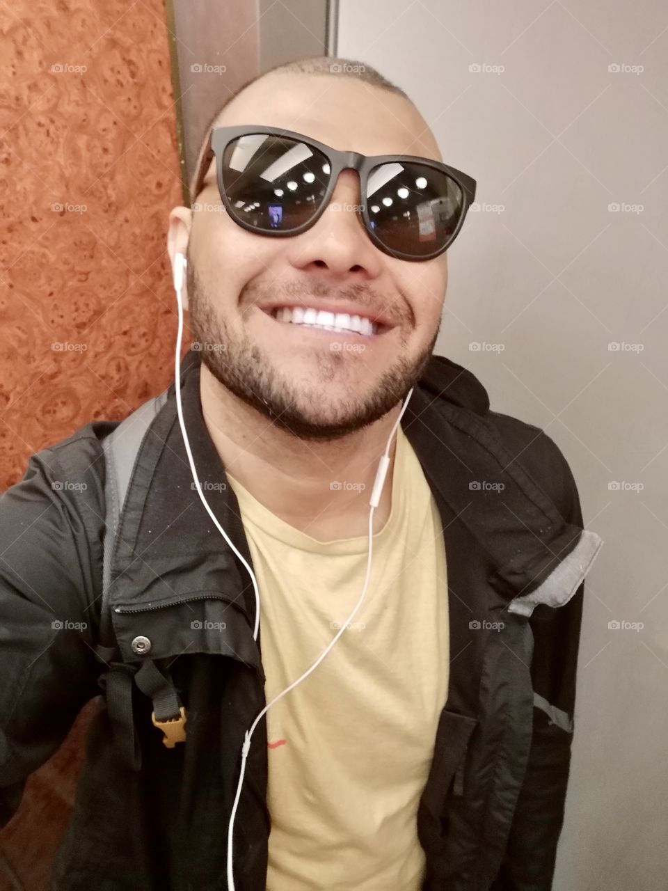 Smiling man with sunglasses, coat and headphones