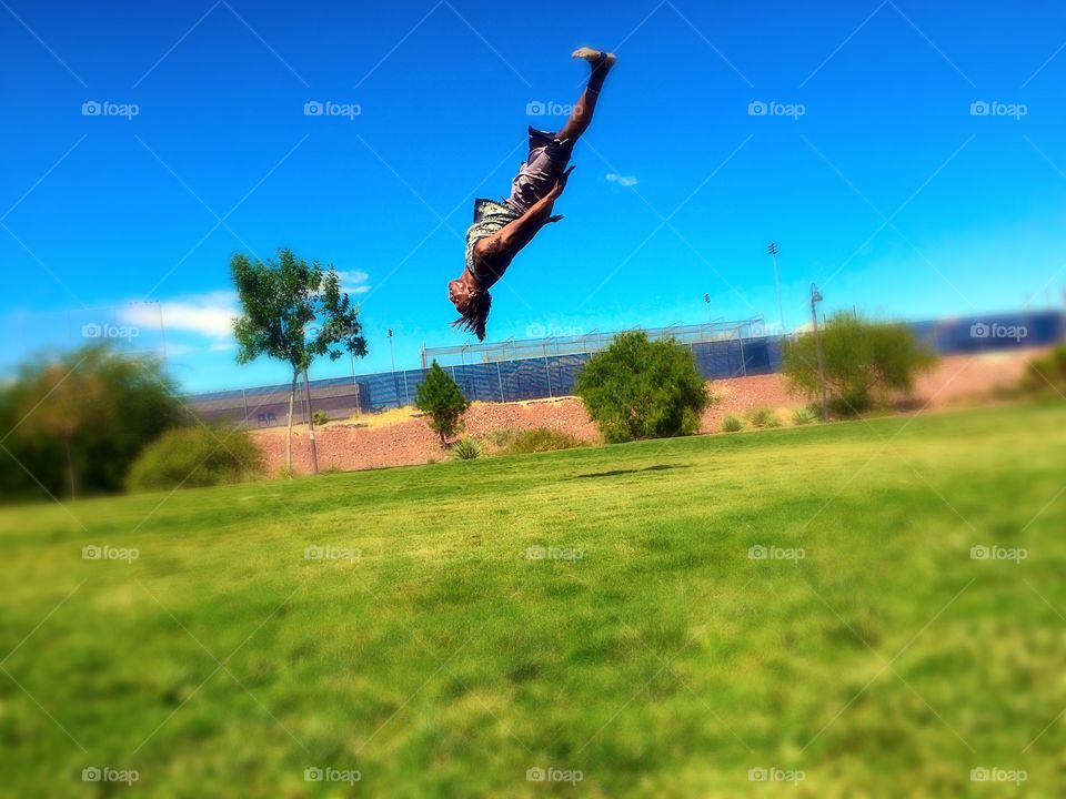 Mid back flip in the park . Kid in the park practicing his flips 