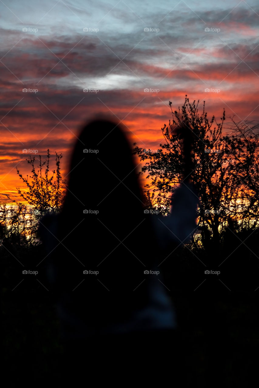 Blurred silhouette of person on sunset background.