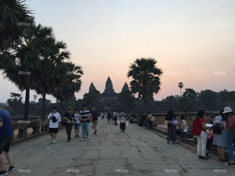 Picture of Angkor Wat temple in Cambodia. Tourists walking on the main entrance to the temple. 