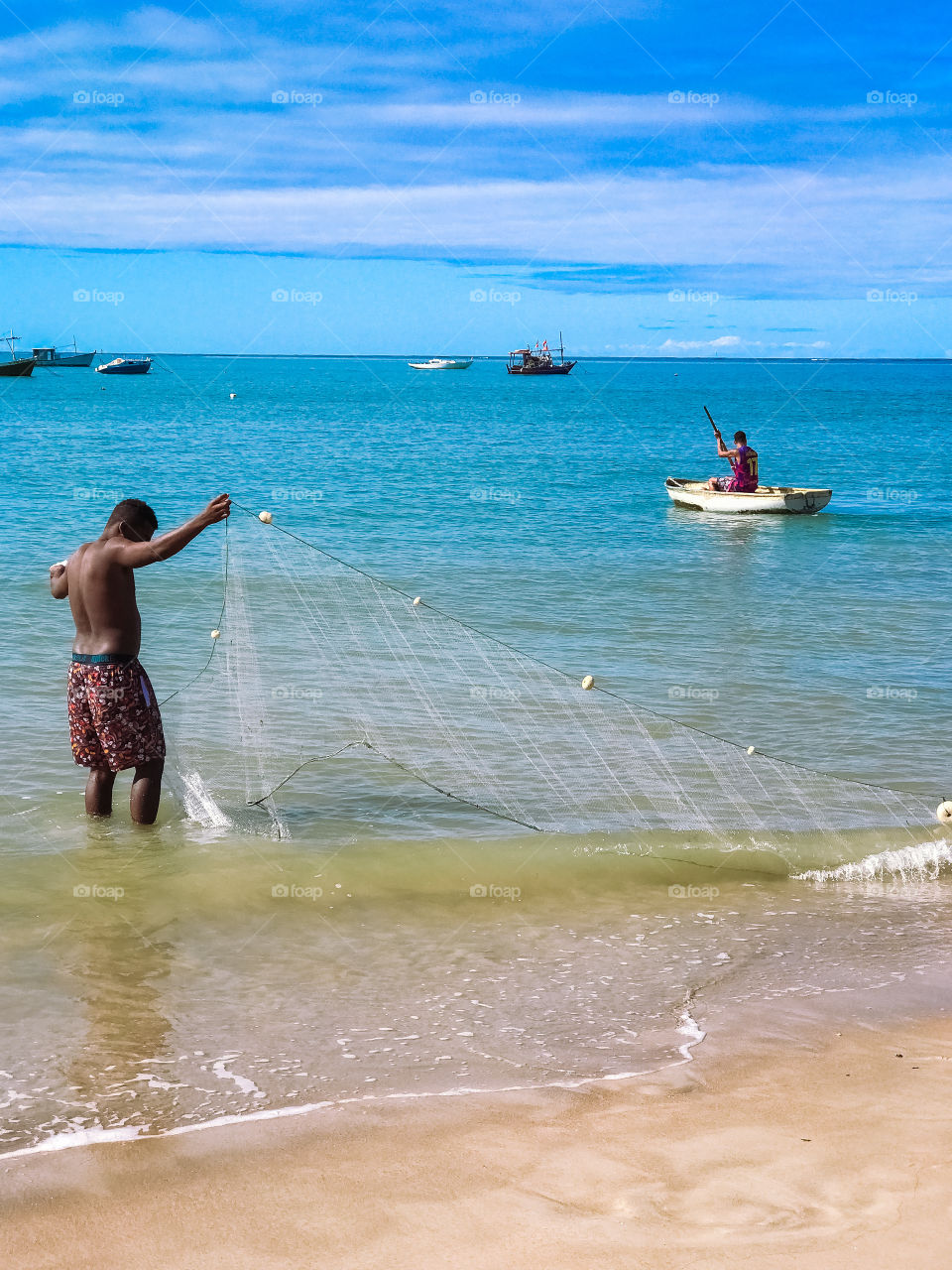 Fisherman catching his food on the red crown beach Bahia Brazil