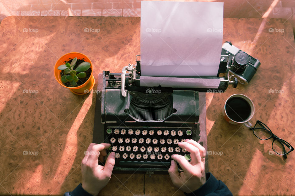 A young writer is writing a new book on an old typewriter.
