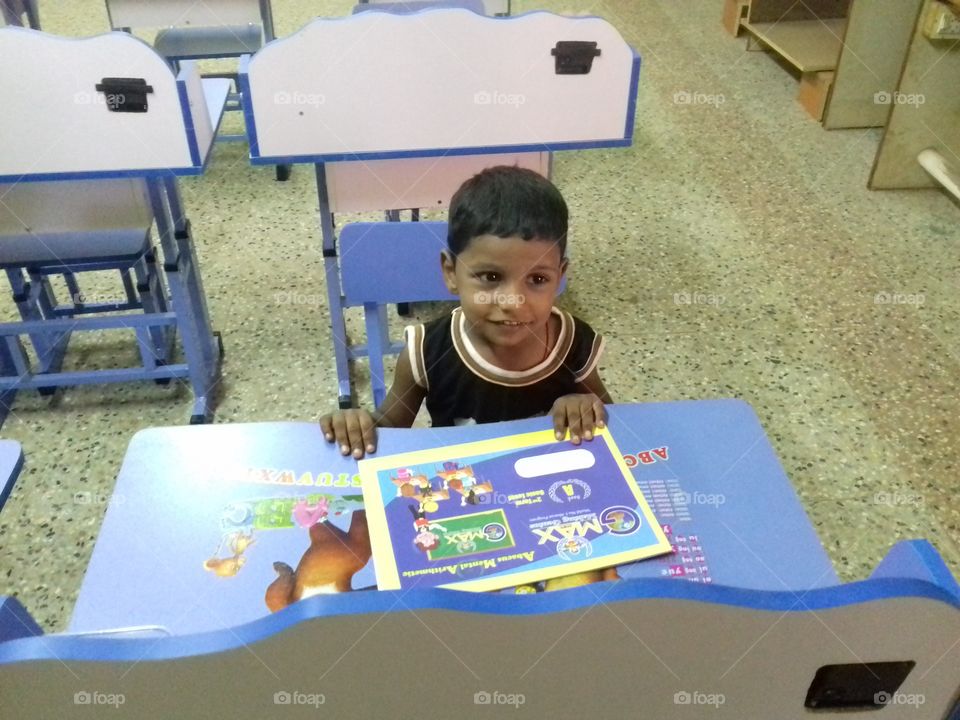 kid sitting in the fancy table in the classroom
